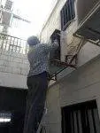 فني تكييف يقوم بصيانة دورية