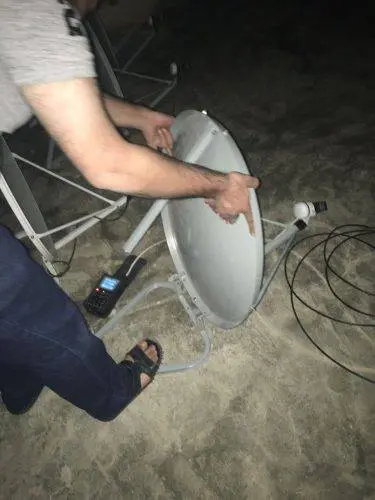 صورة فني أثناء تركيب الطبق وضبط الإشارة عامل يقوم بتركيب طبق دش فوق السطح