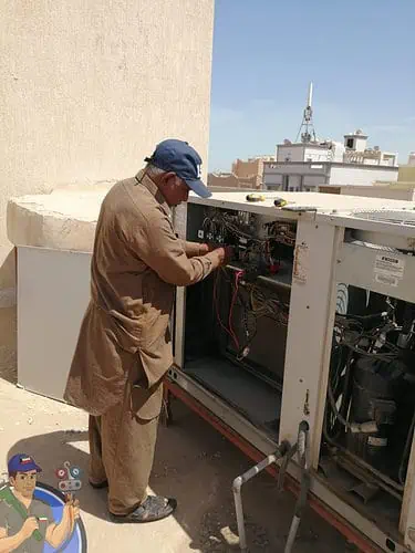فني يقوم بصيانة تكييف مركزي